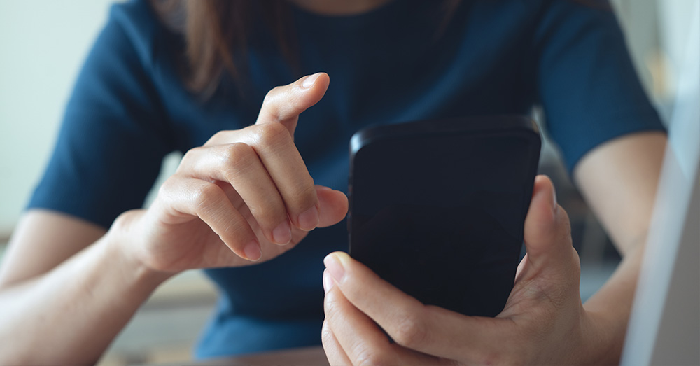 An image of a shopper about to click on something on her mobile device.