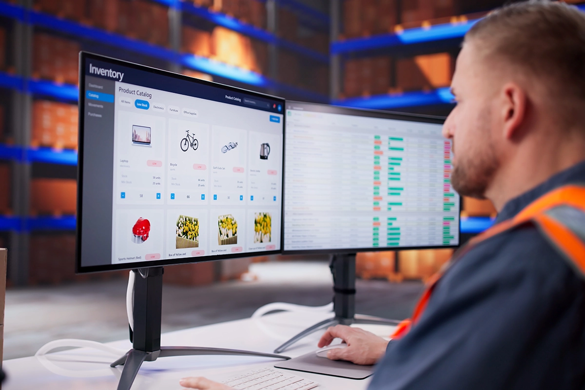 Warehouse worker responsible for ecommerce reverse logistics adds pristine returned items back into available inventory using a desktop computer
