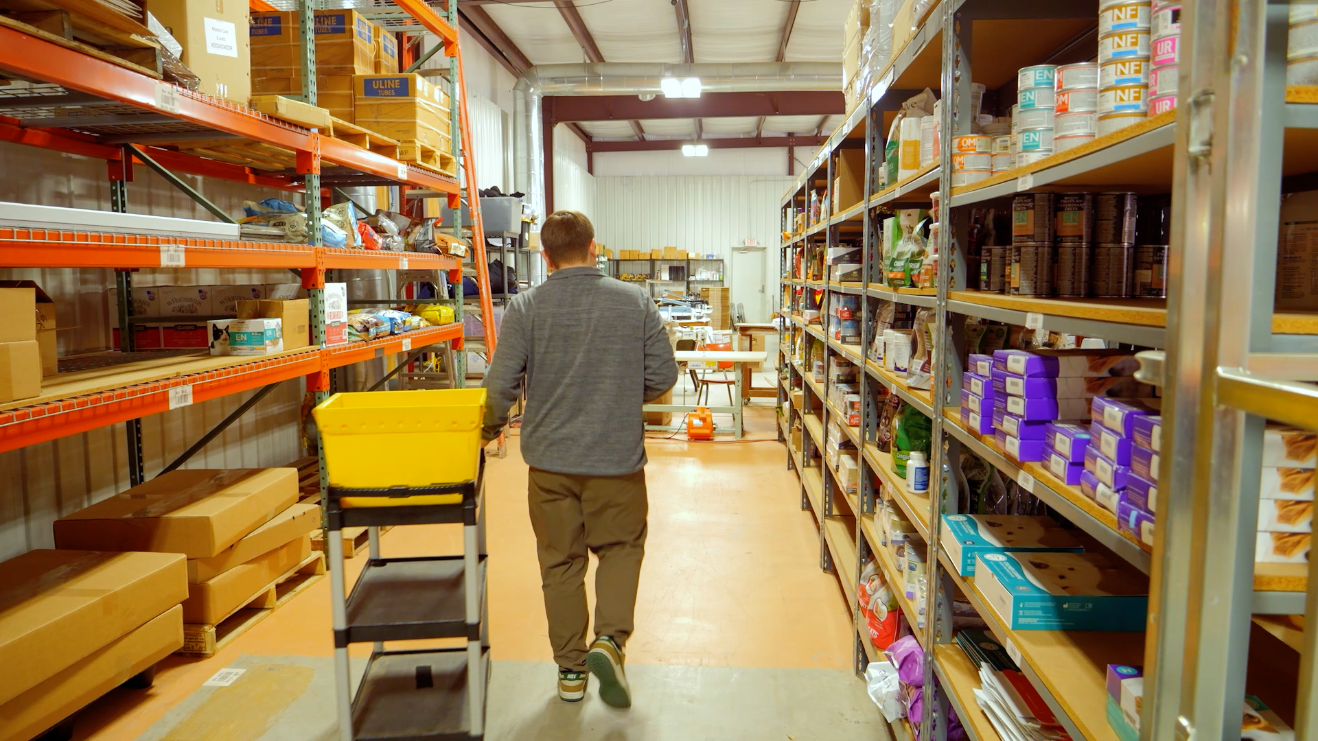 Warehouse worker in aisle with empty shelves representing stockouts