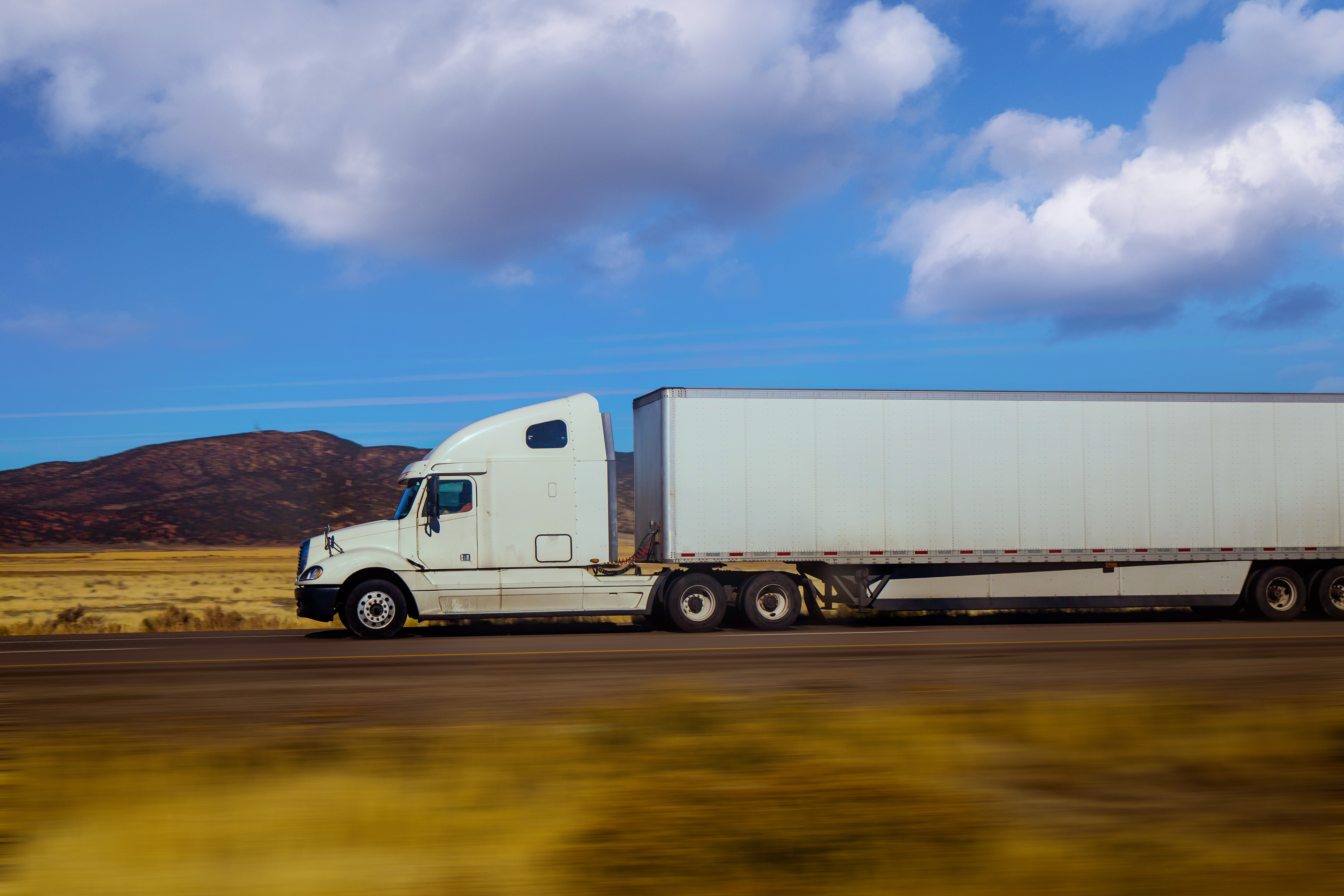 White semitruck driving on freeway