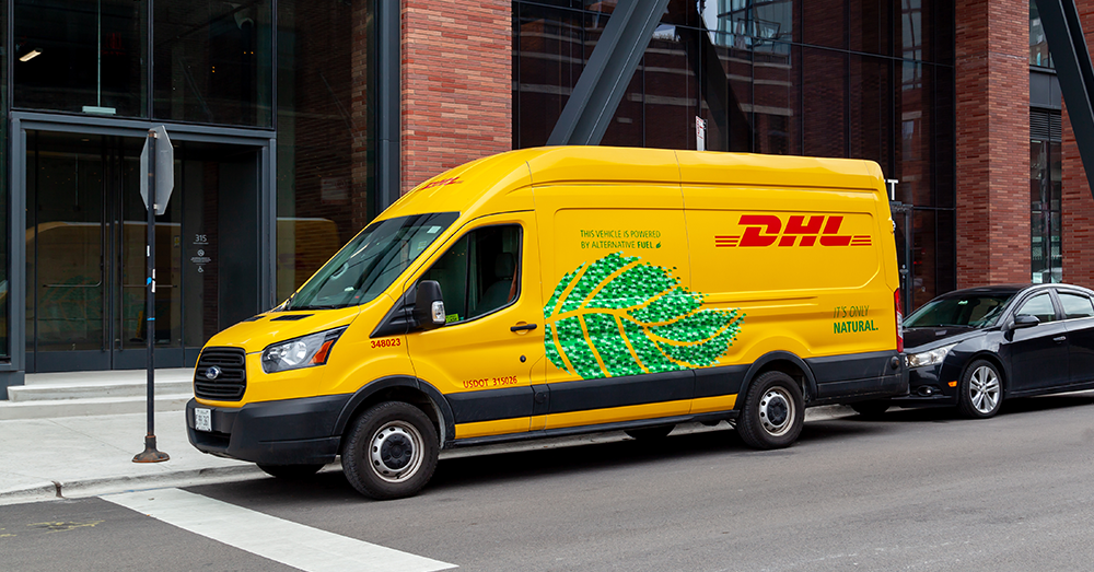 An image of a DHL delivery van parked outside an office building.