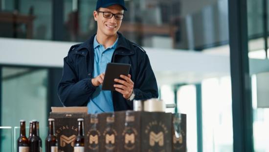 Beverage distribution industry worker on tablet with beer on table