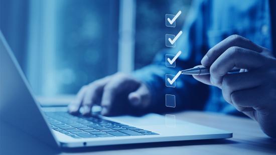 Ecommerce business leader with laptop and checklist looking for the best Shopify shipping apps