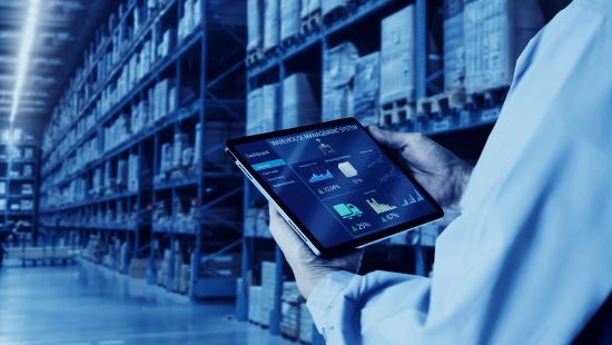 Warehouse worker using a mobile device with warehouse management software to master purchasing and receiving
