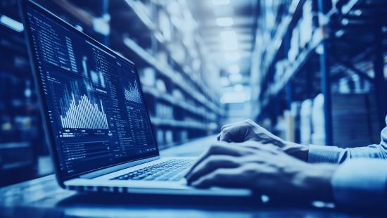 Warehouse worker using a laptop computer for predictive purchasing and predictive restocking 