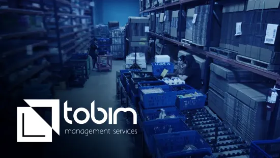 Image of warehouse workers making a pull. The Tobim logo is featured