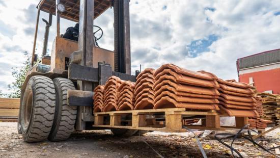 Forklift carrying a pallet of roof tiles