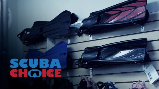 Scuba Choice diving fins displayed on a retail wall rack with brand logo overlay
