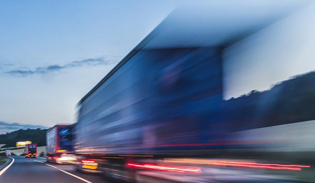 Blurred image of a transport truck driving on the highway