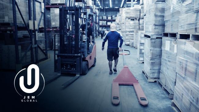Warehouse worker loading supplies. The JEM logo is overlayed in the bottom left