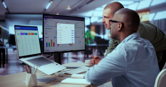 Two trade compliance professionals reviewing denied party screening software